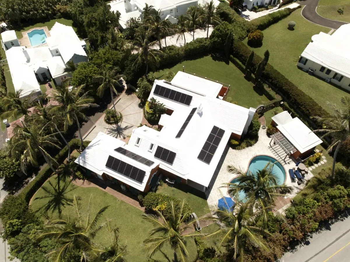 A private residence in Bermuda with Maxeon solar panels on a white roof, seen from the air