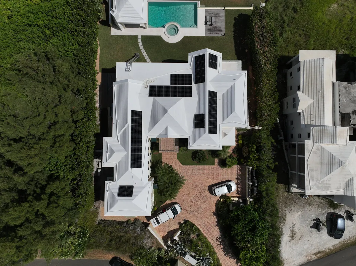 A private residence in Bermuda with Maxeon solar panels on a white roof, seen from the air