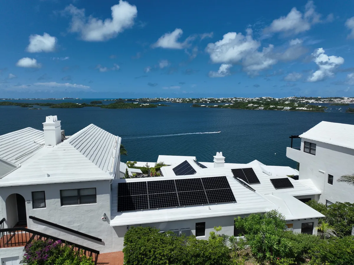 A private residence in Bermuda with Maxeon solar panels on a white roof, seen from the air