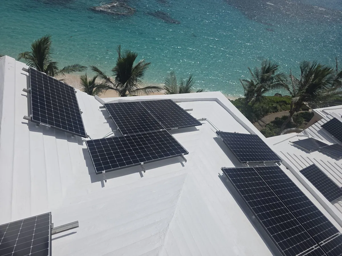 Rows of solar panels on the white roofs of The Reefs, Southampton, above the beach