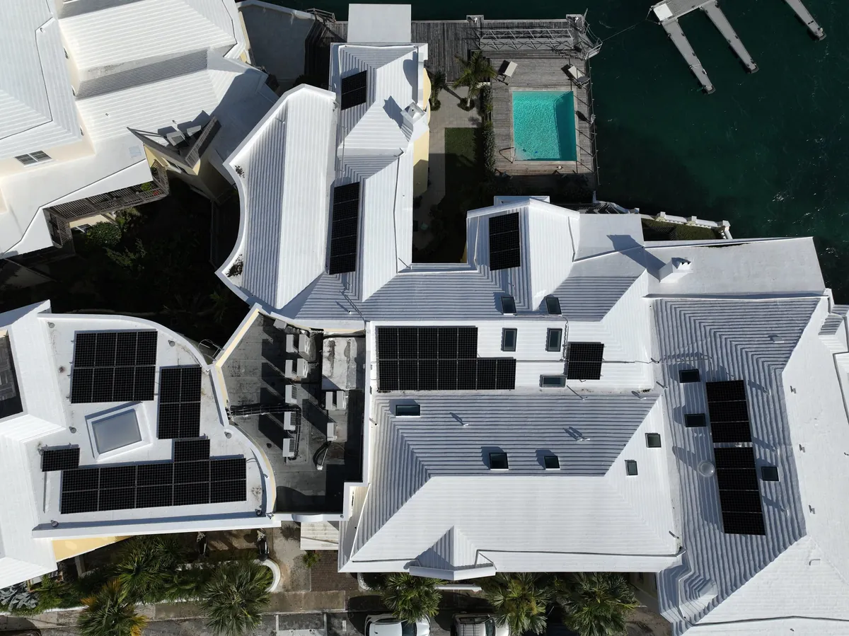 Solar panels across the roofs of The Wharf on Harbour Road, Paget, beside the water, seen from directly above